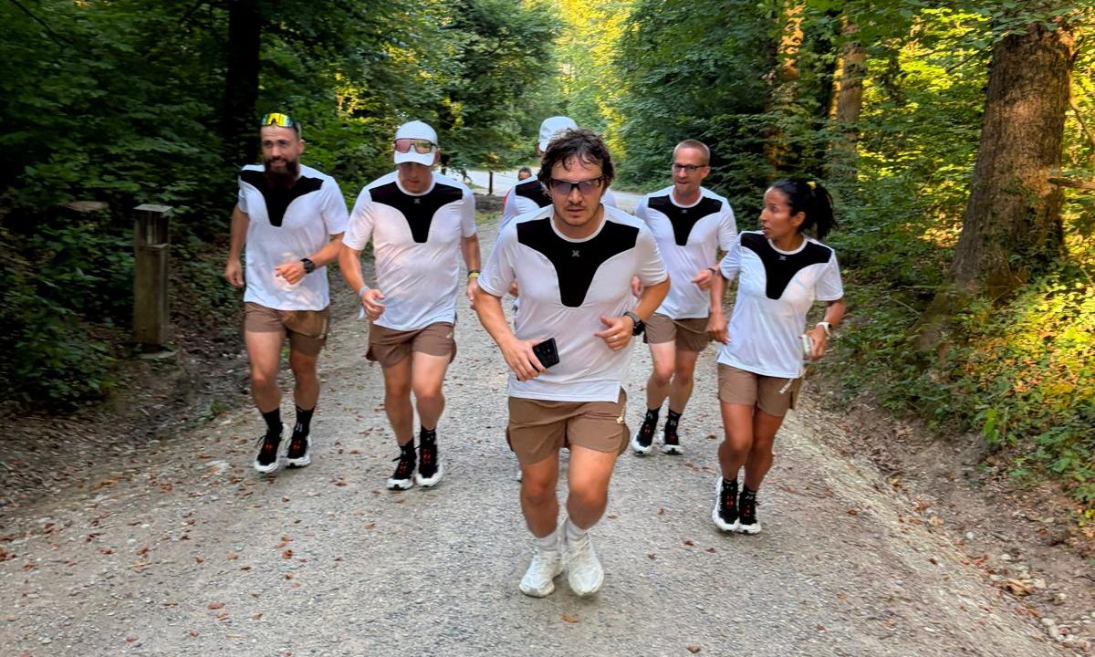 Six runners of the squad on a gravel path in the woods